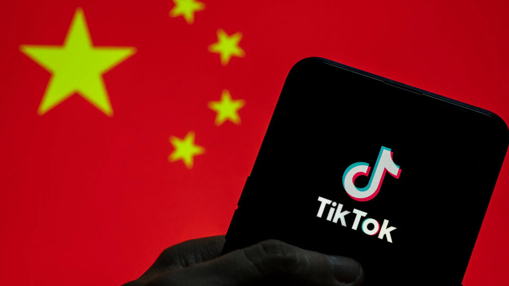 A smartphone running TikTok in front of a Chinese flag (Image view New York Post)