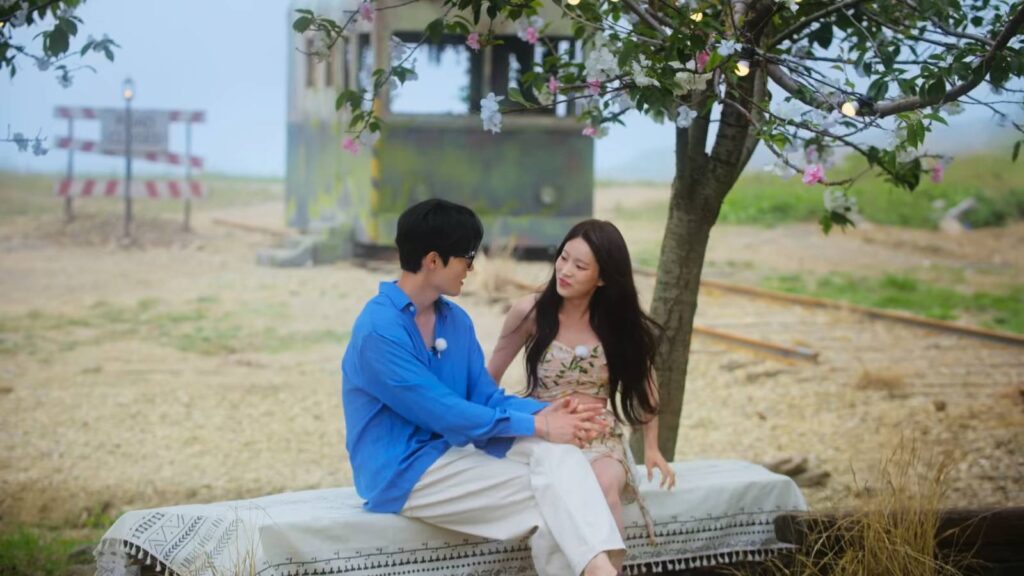 Kook Dong-ho and Kim A-rin under a blooming tree (image via Netflix)